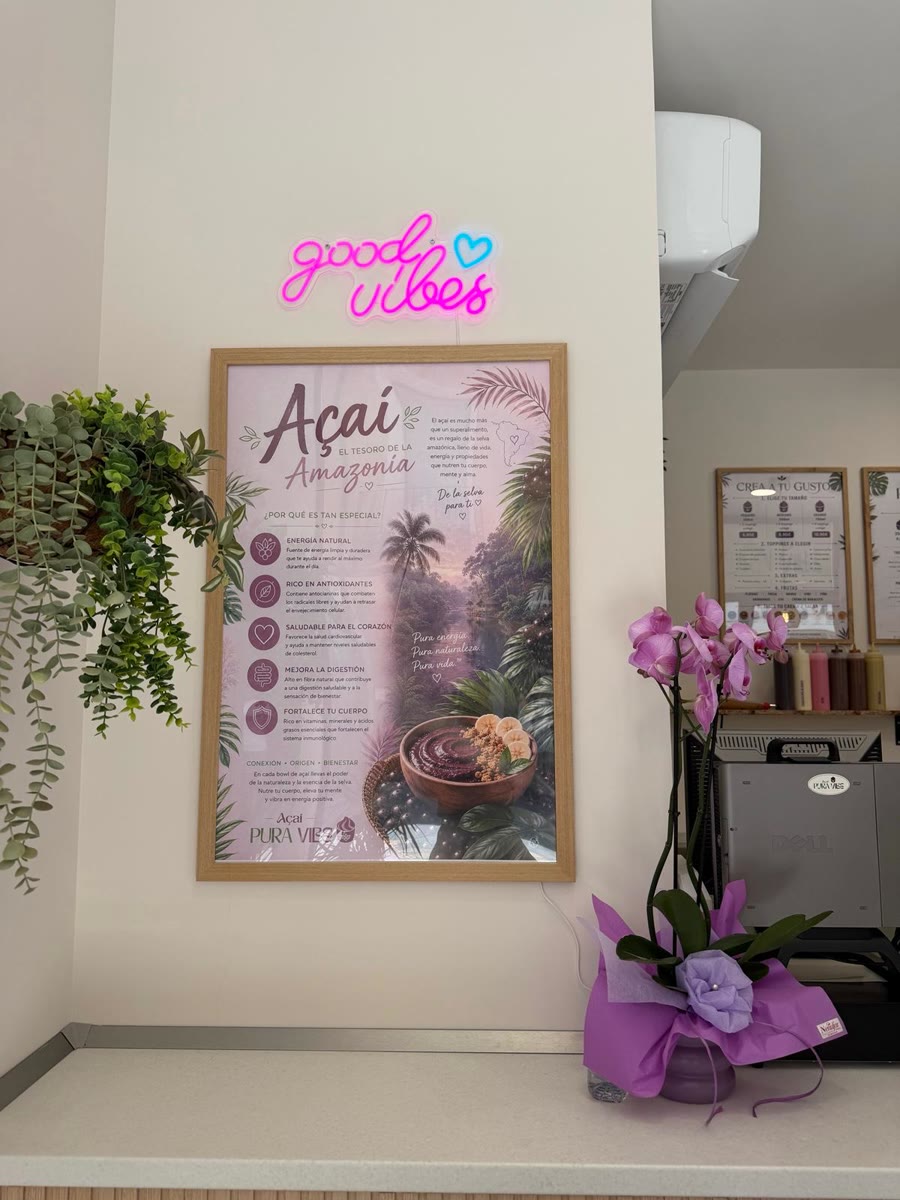 La pared del local con el cartel del açaí, las plantas y la orquídea